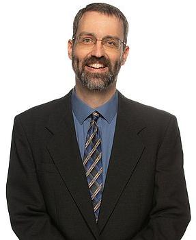 Headshot photo of Eric James standing in front of a white background.